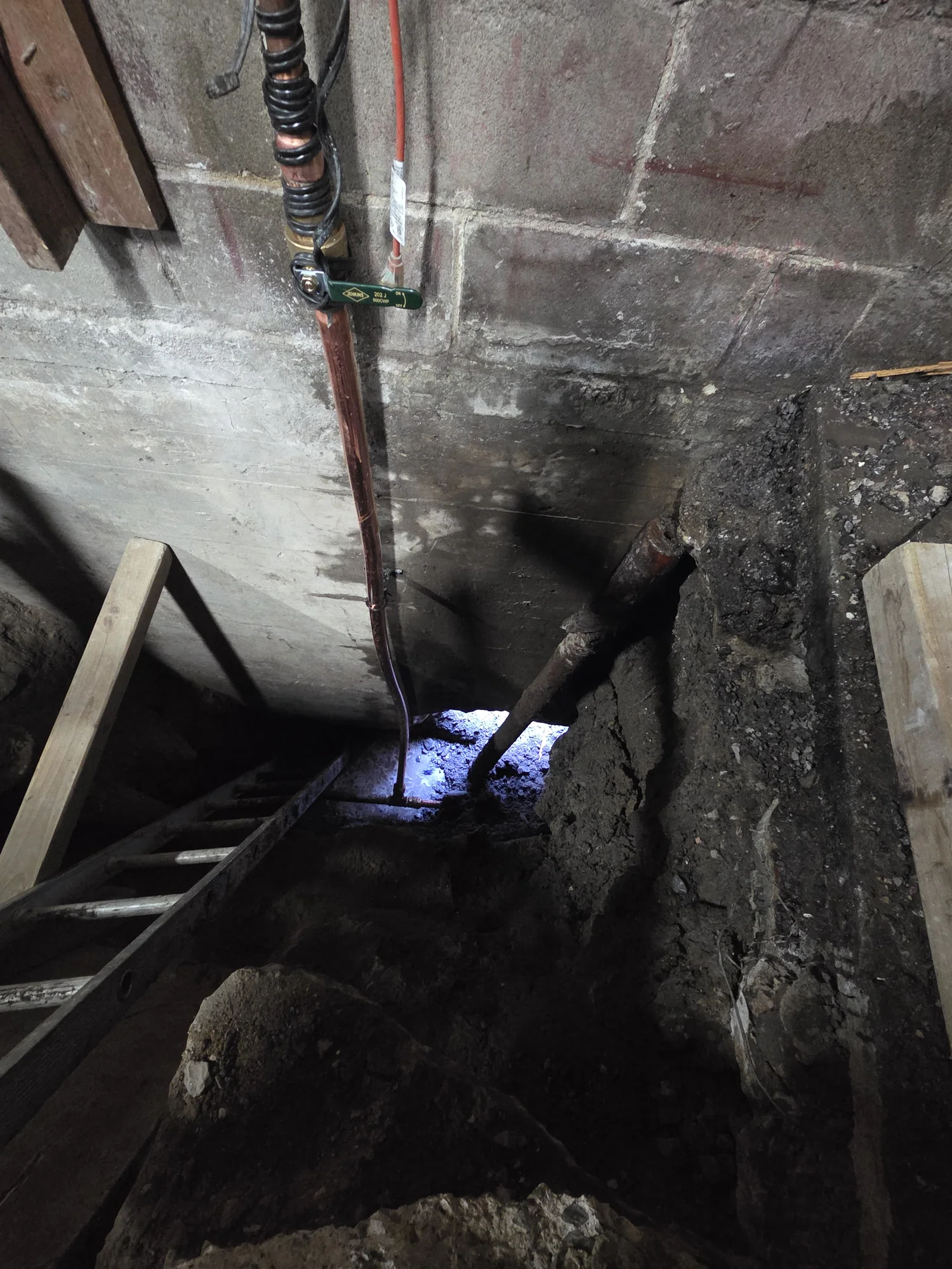 Copper service pipe repair inside a basement excavation