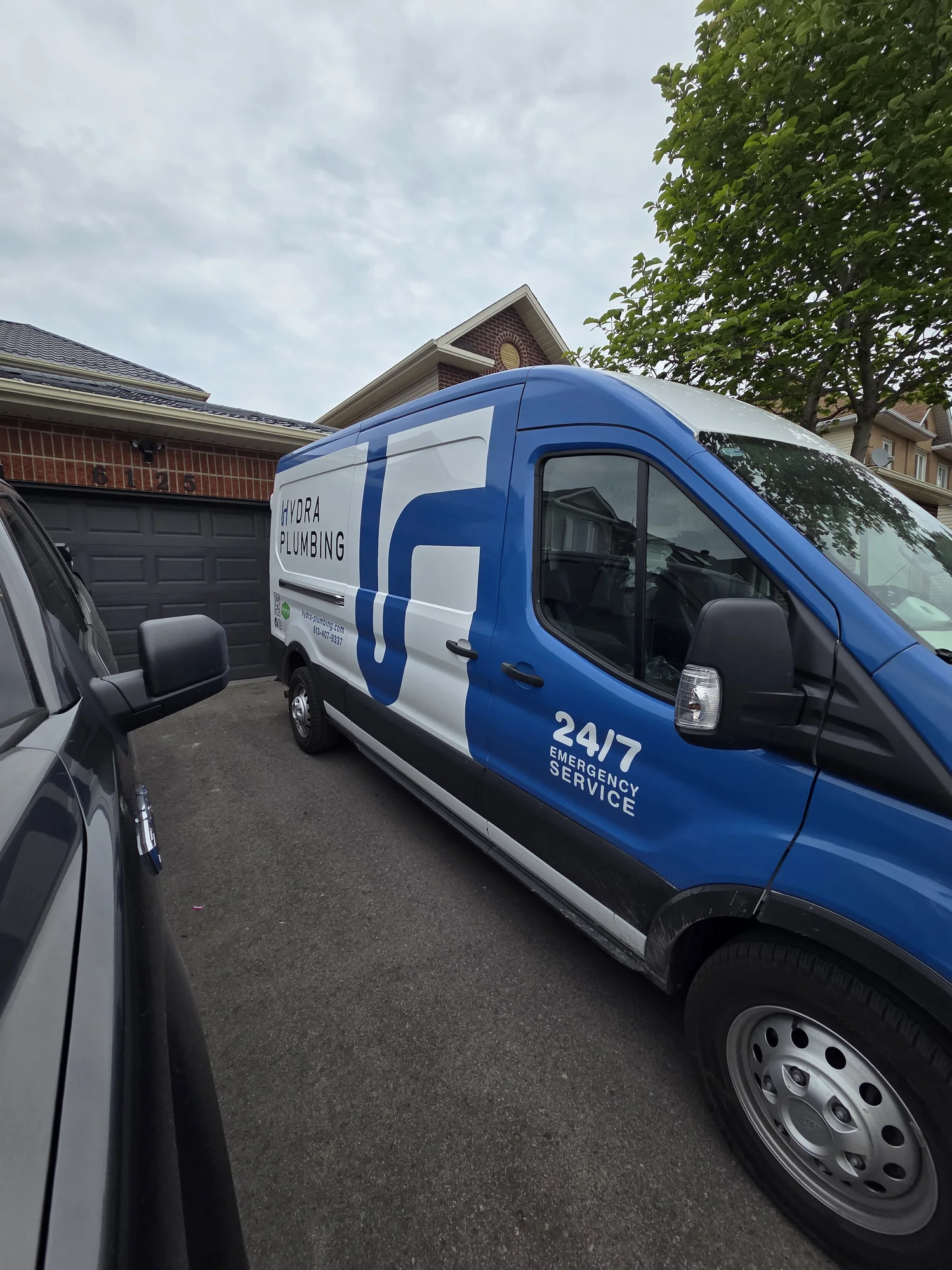 Passenger-side view of the Hydra Plumbing service van