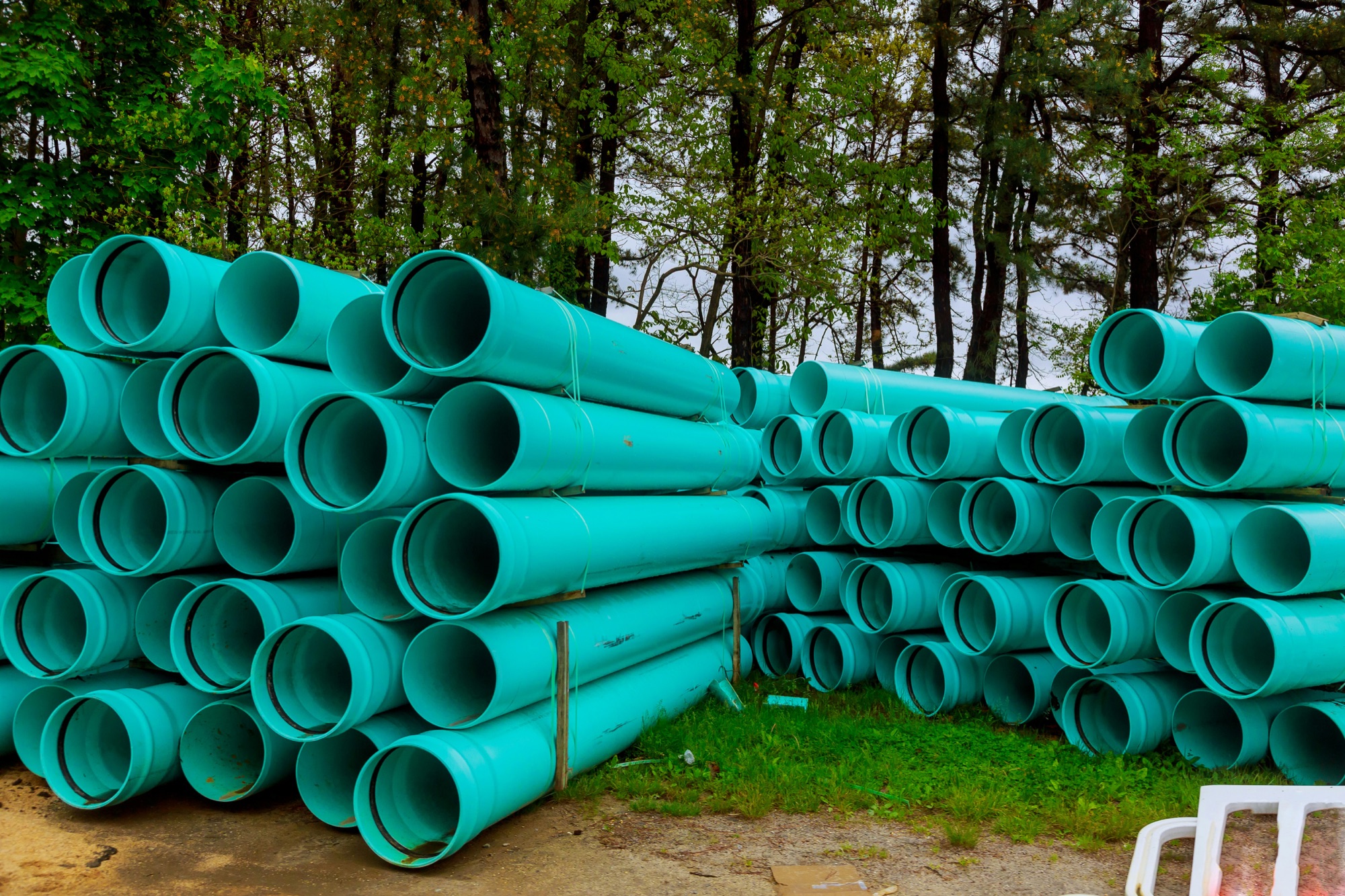 Stacks of green underground sewer and drainage pipe