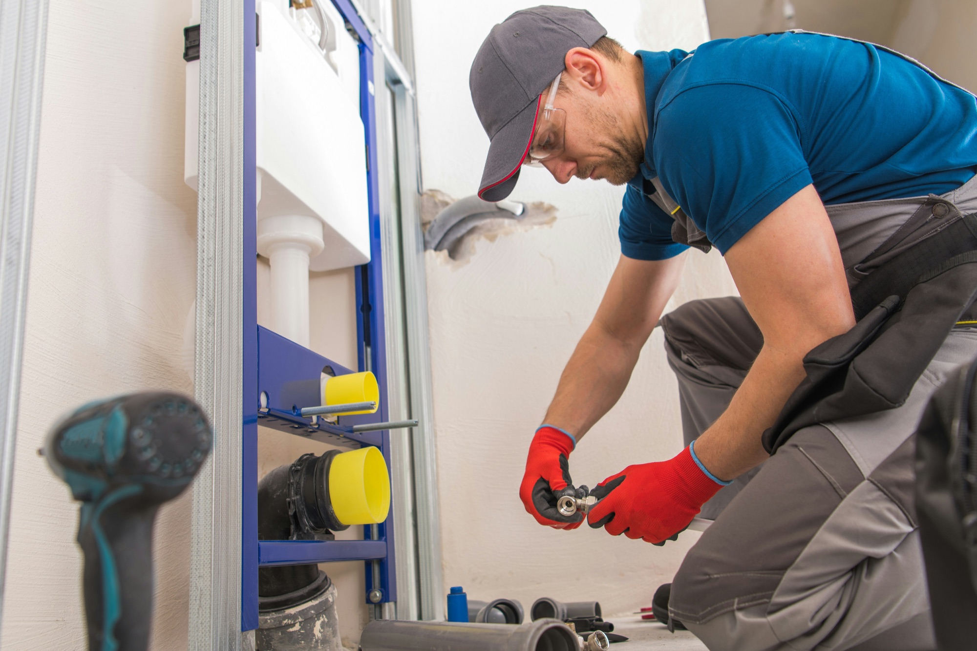 A plumber installing the concealed frame for a wall-hung toilet