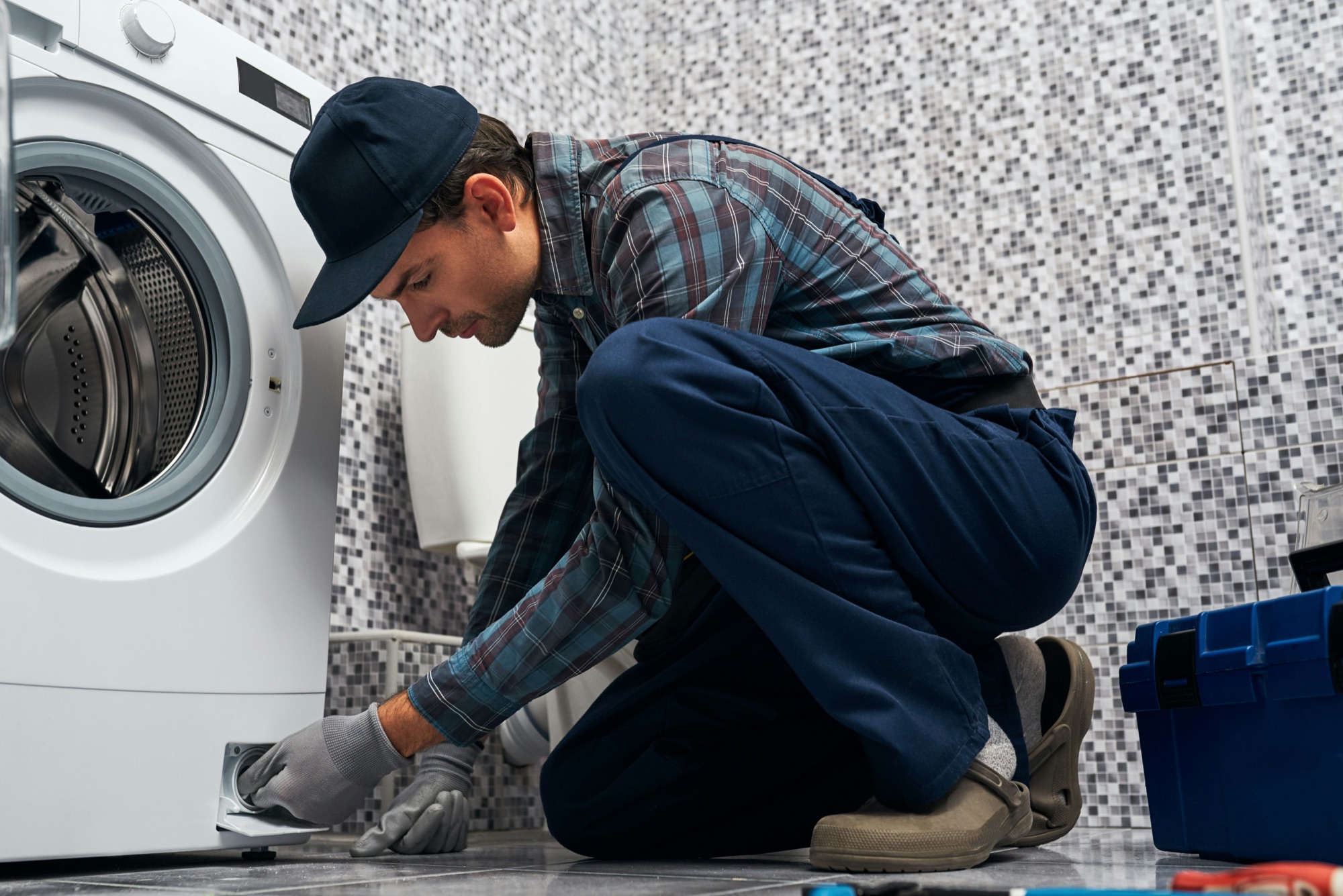 A plumber connecting a washing machine water line