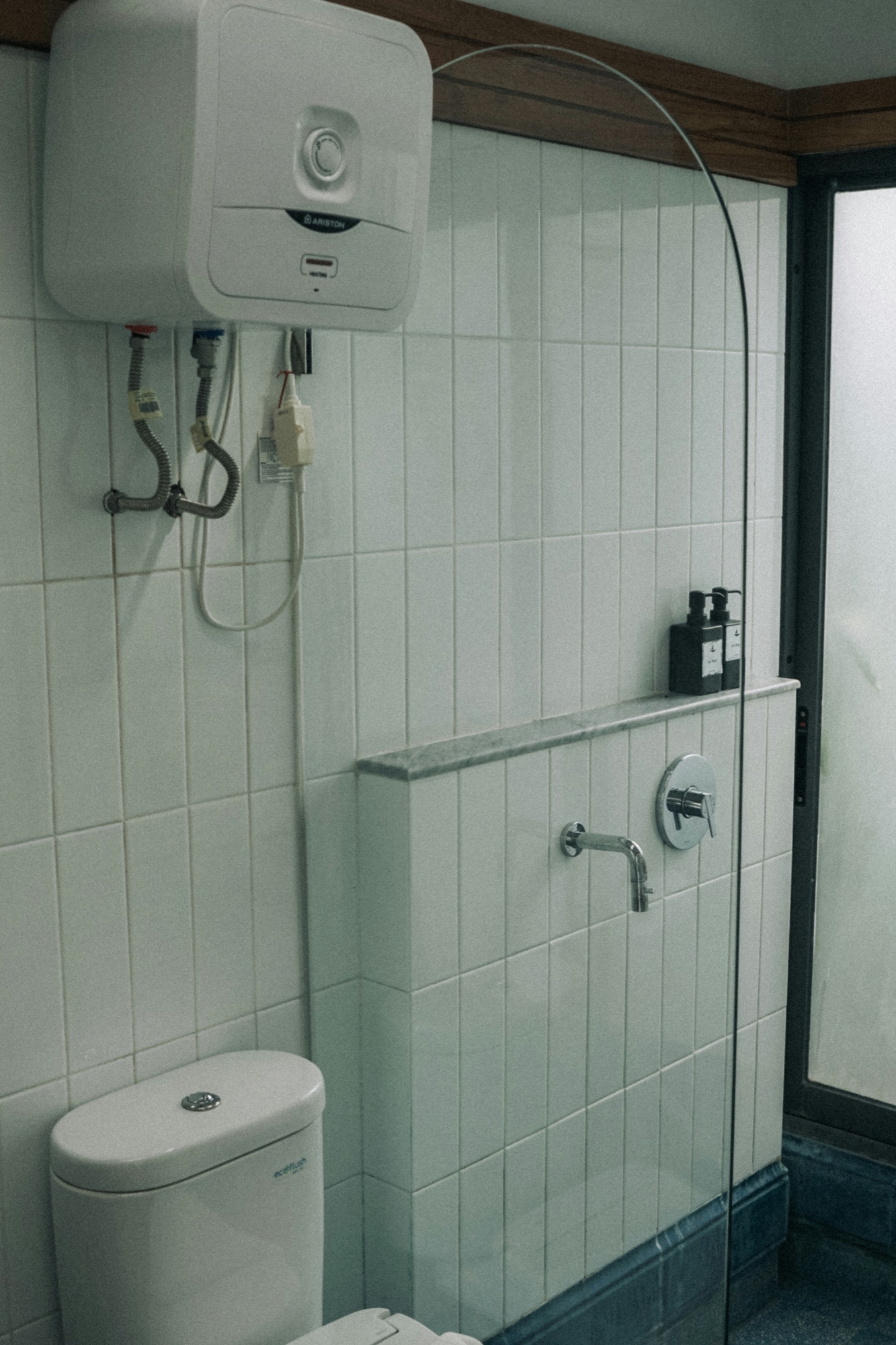 Compact electric water heater installed above a bathroom fixture