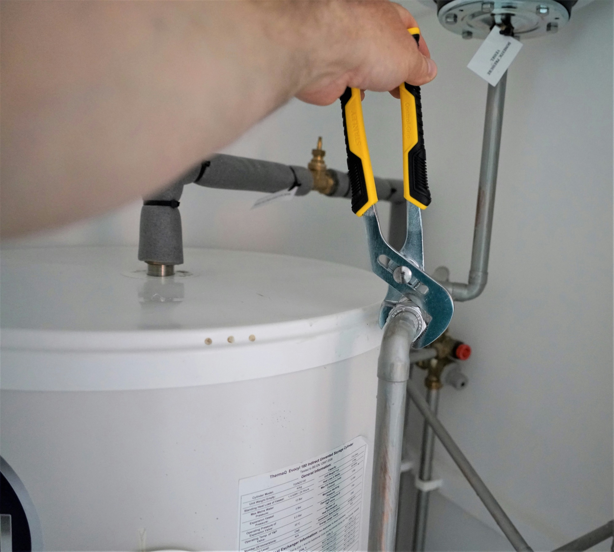 A valve being serviced beside an electric water heater